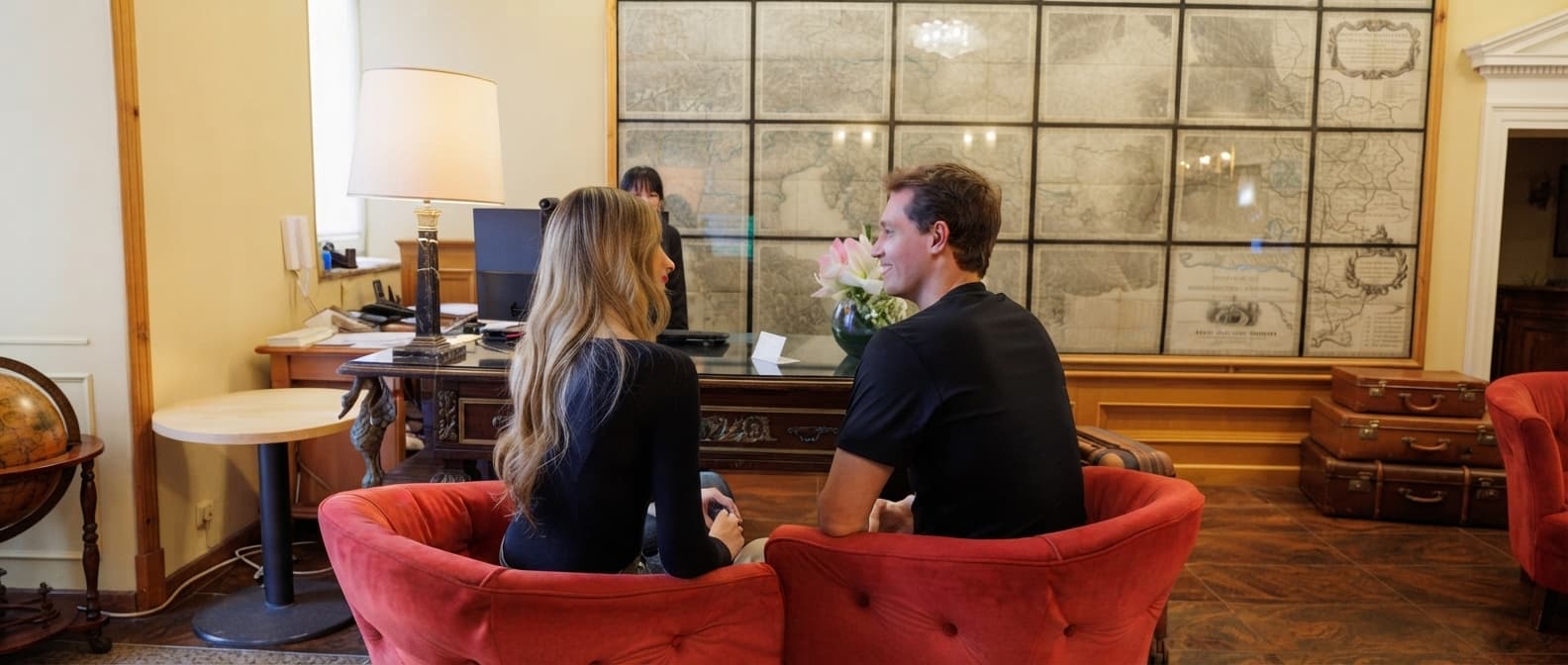 Guests sitting in plush armchairs at the historic lobby reception desk