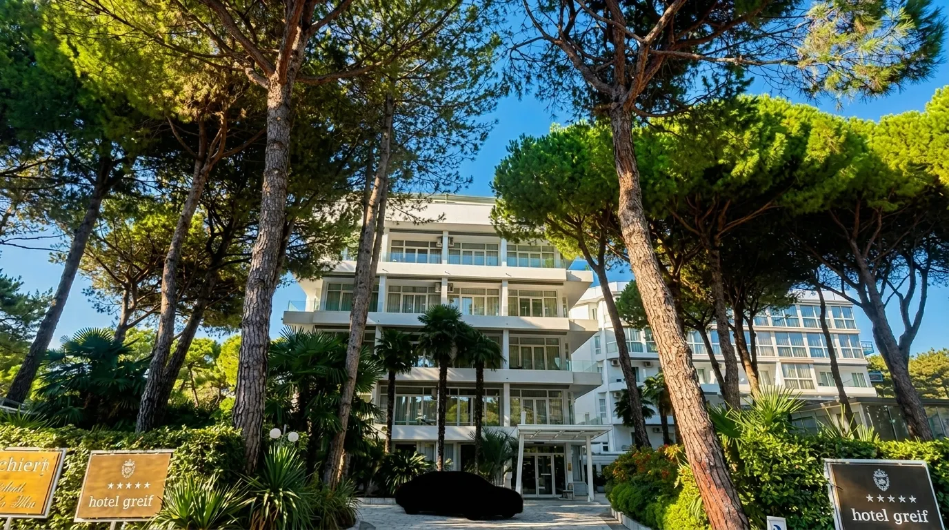 Hotel Greif facade framed by mature maritime pine trees